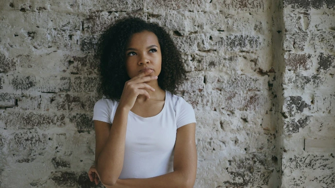 Young woman with hand on chin thinking