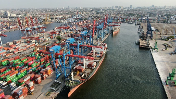 Busy shipping port with cranes and cargo containers